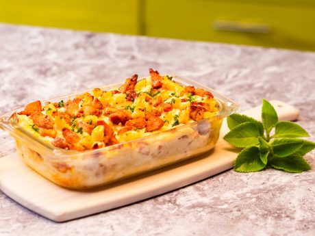 Molde de pasta alfredo al horno sobre mesa de cocina